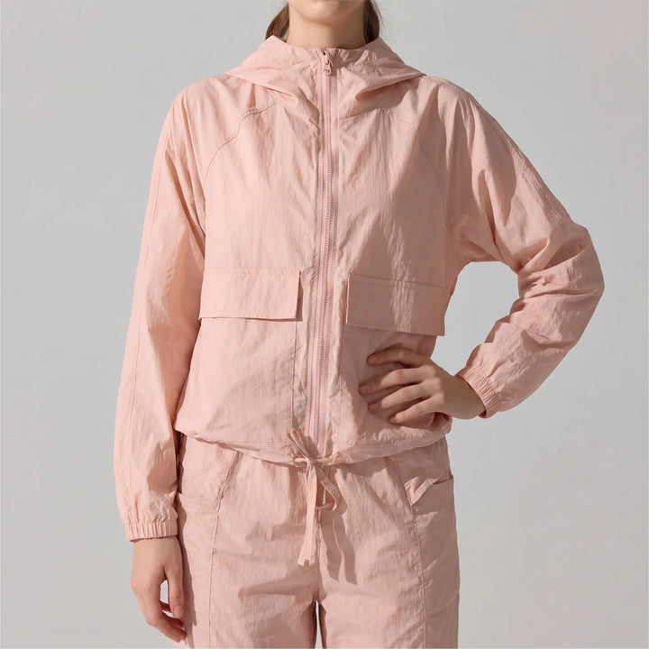 Agile women's lightweight running jacket with hood, designed for outdoor active movement & wind protection.