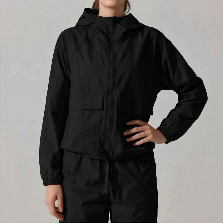 Durable, lightweight women's hooded sports jacket; ideal windbreaker for athletic outdoor adventures.