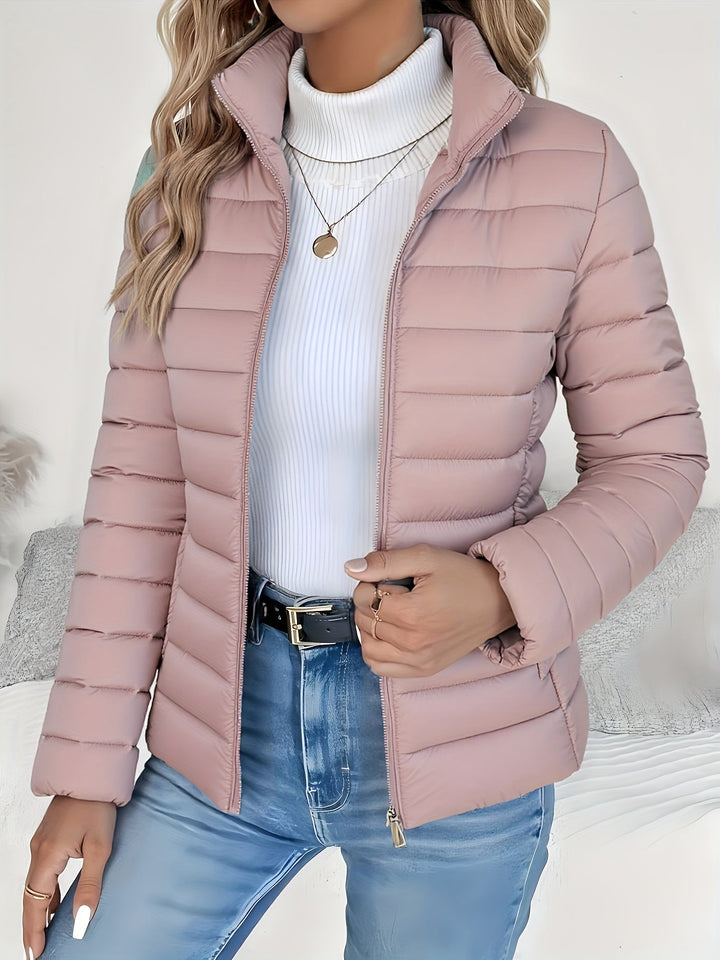 Casual women's quilted jacket featuring a stylish stand collar and full zip. Ideal lightweight layering piece for fall fashion.