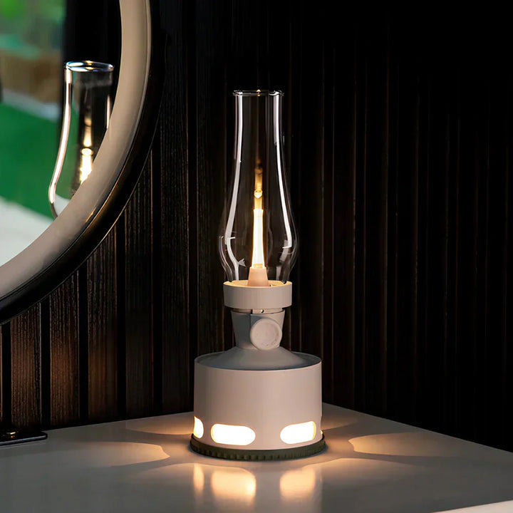 Outdoor scene with a LumaLantern rechargeable vintage LED lantern hanging from a tree branch, portable ambiance