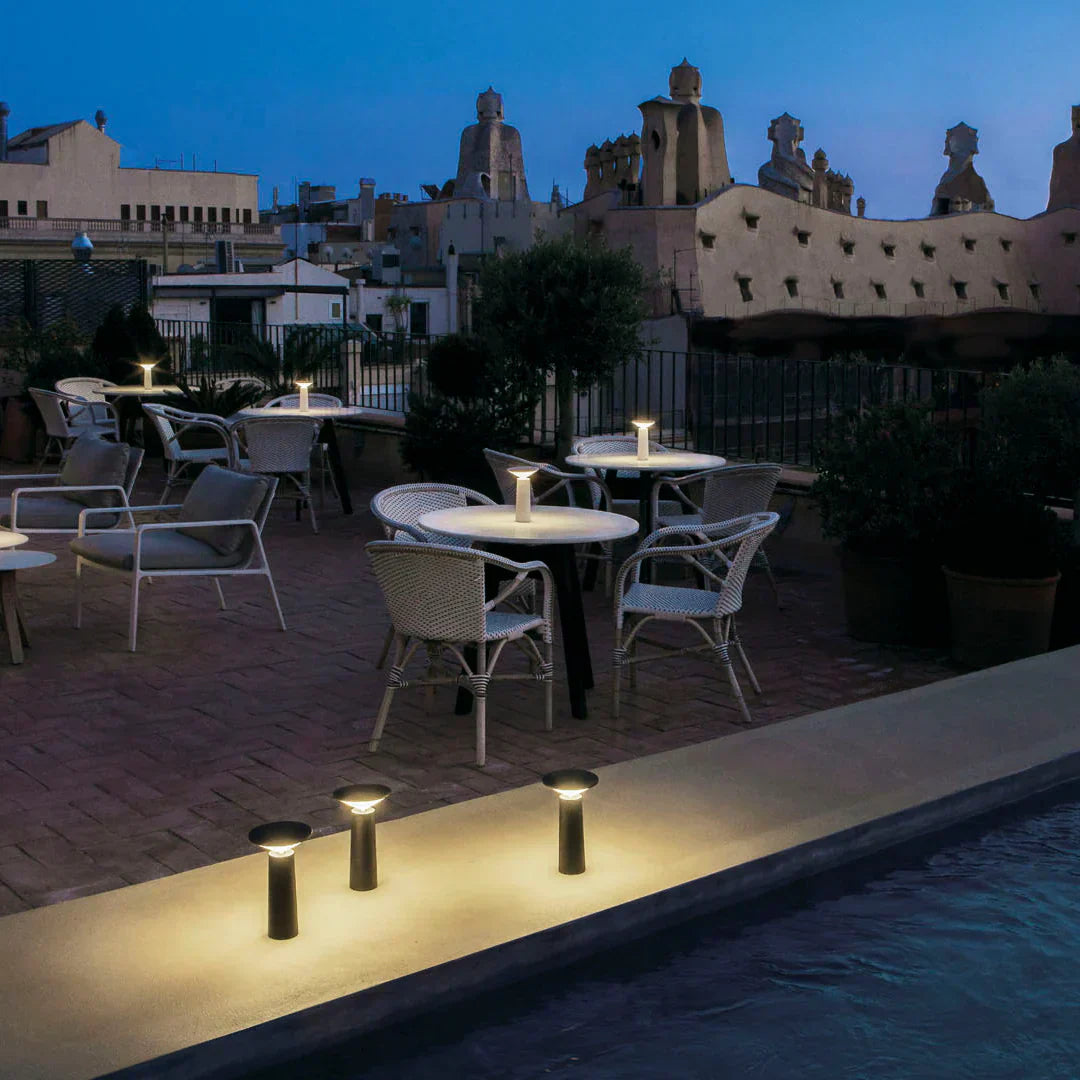 Flexible LumoFlex portable table lamp, providing dimmable LED light for modern living and outdoor settings.