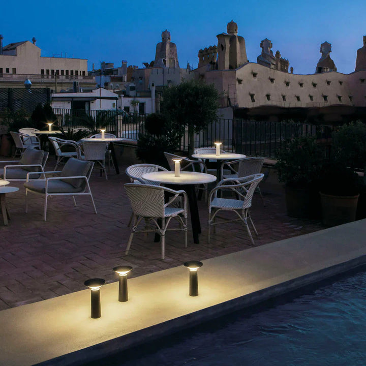 Flexible LumoFlex portable table lamp, providing dimmable LED light for modern living and outdoor settings.