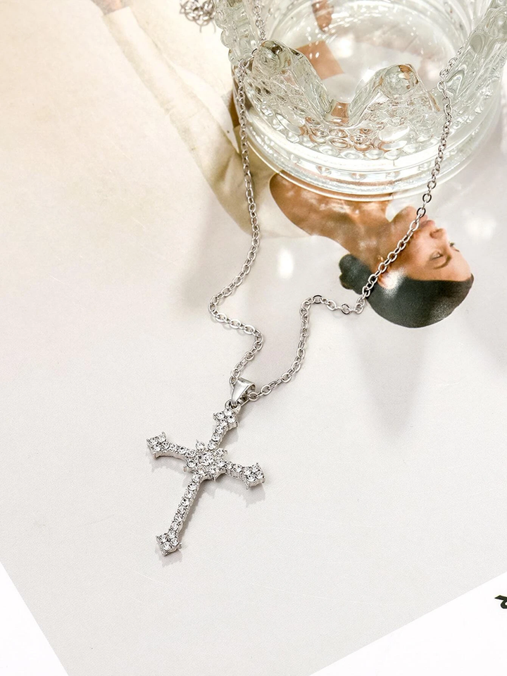 Fashionable women's silver necklace with a luxurious zircon crystal cross pendant. Modern elegant religious jewelry.