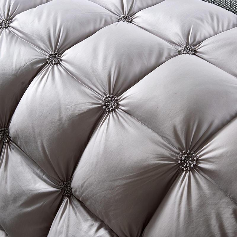 Elegant corner detail of PlumeLux luxury goose down duvet, showcasing piped edging & soft cotton fabric.
