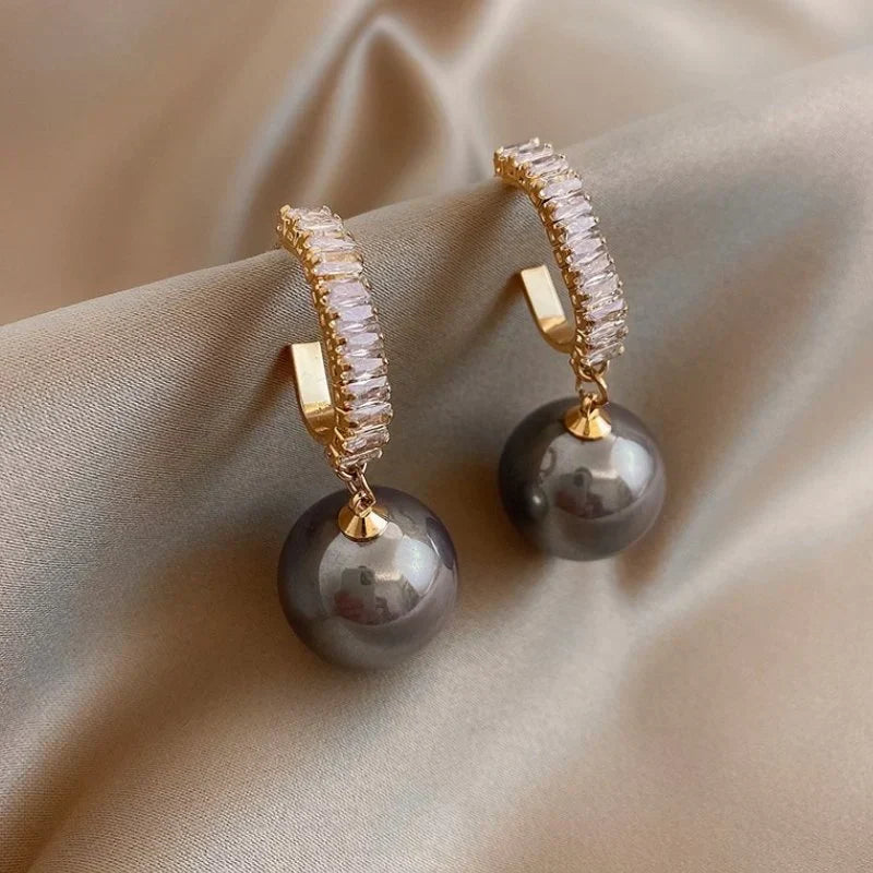 Luxury women's dangle earrings featuring elegant pearls and sparkling zirconia, perfect for a chic, classic look.