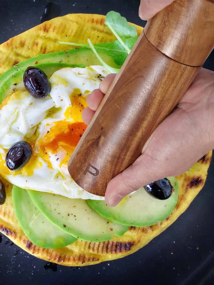 Premium wooden salt and pepper grinders on a stylish tray. Essential luxury kitchen seasoning tools.