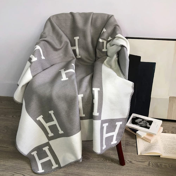 Warm and inviting wool cashmere plaid throw, perfect for draping over a bed or sofa, enhancing home decor.