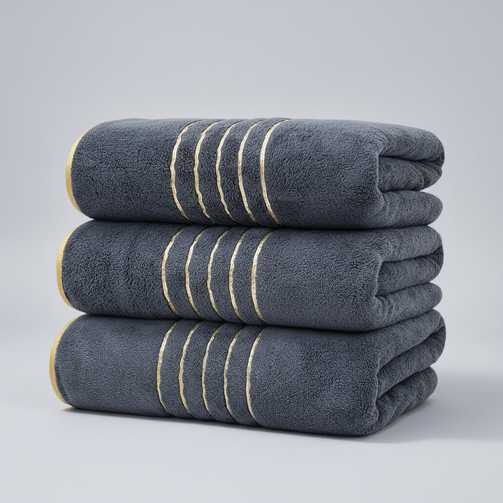 Elegant LuxuryWrap absorbent microfiber towel set folded neatly on a bathroom shelf, hinting at luxury.