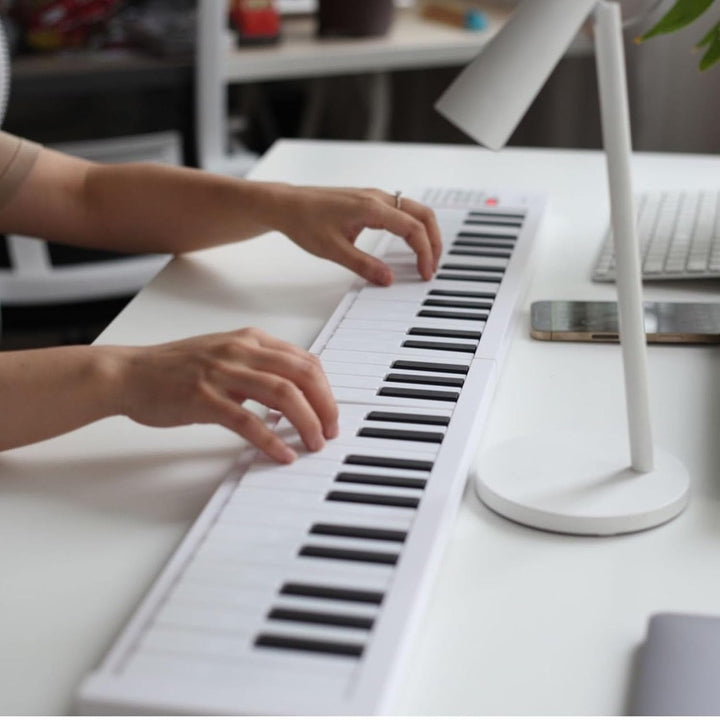 Portable 61-key Meliora digital piano folded for easy transport, showing compact design.