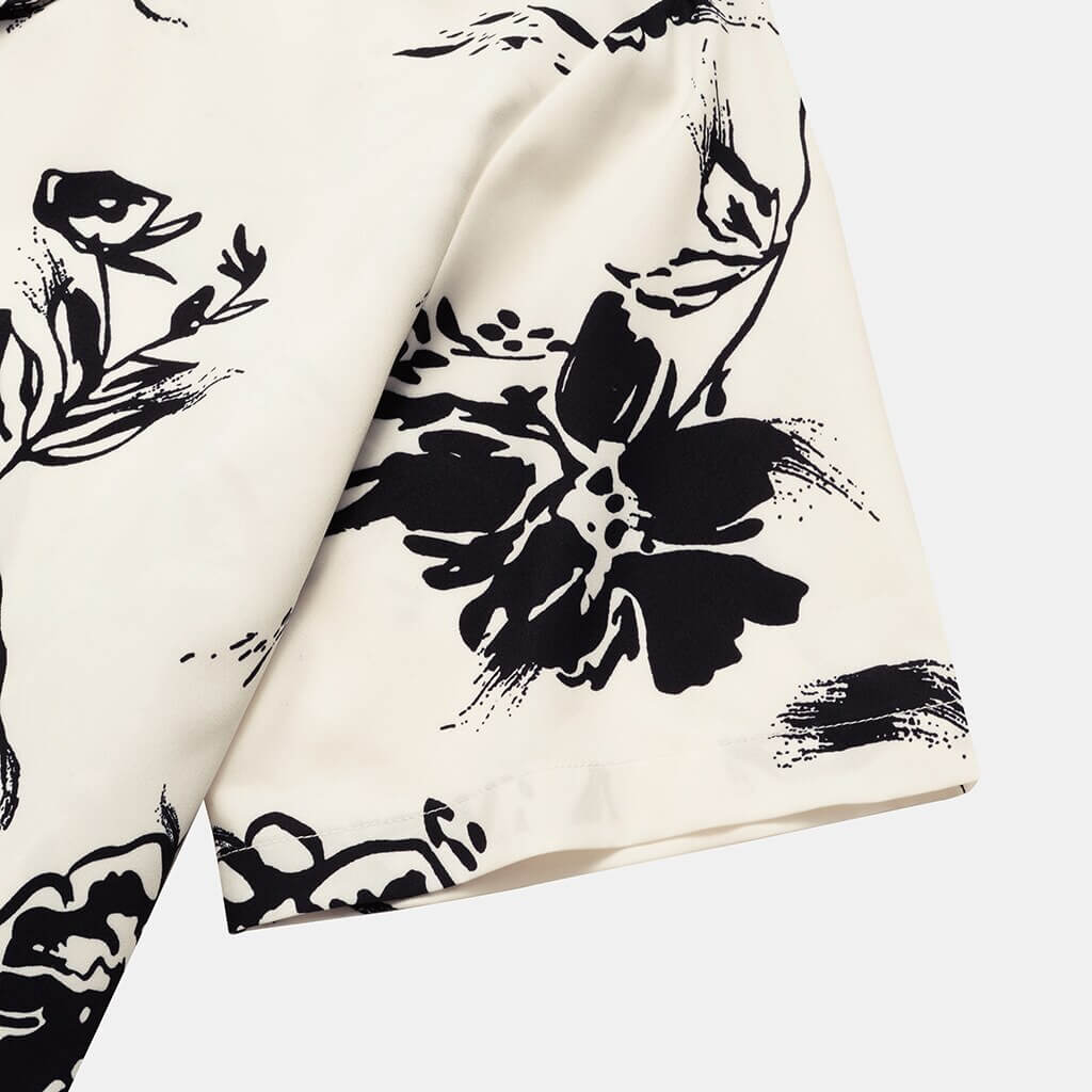 Styled men's tropical print shirt with sunglasses, ready for a beach vacation or casual summer event.