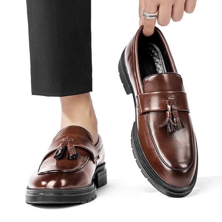Polished black leather Belmont men's tassel loafers, offering a timeless and sophisticated look.