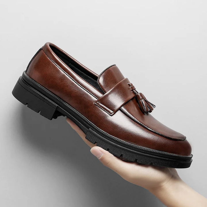 Close-up: Shiny black Belmont men's tassel loafers, highlighting classic design and elegant polished finish.