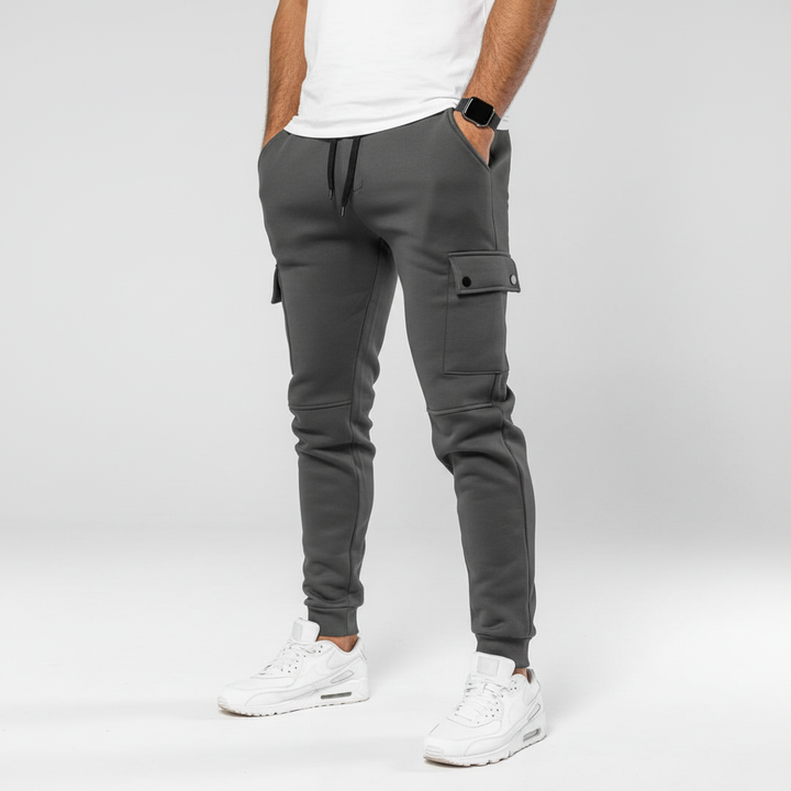 Stylish dark grey men's cropped joggers featuring practical pocket. Ideal for casual wear or workout.