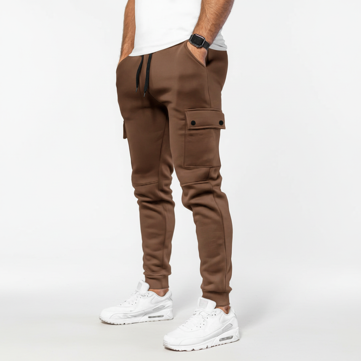 Flexible men's black cropped joggers with a secure pocket. Designed for active movement & workouts.