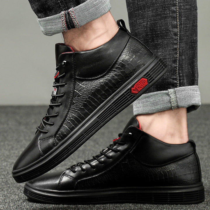 Side view of men's black high-top sneakers featuring red lace details & sole accents for street style.