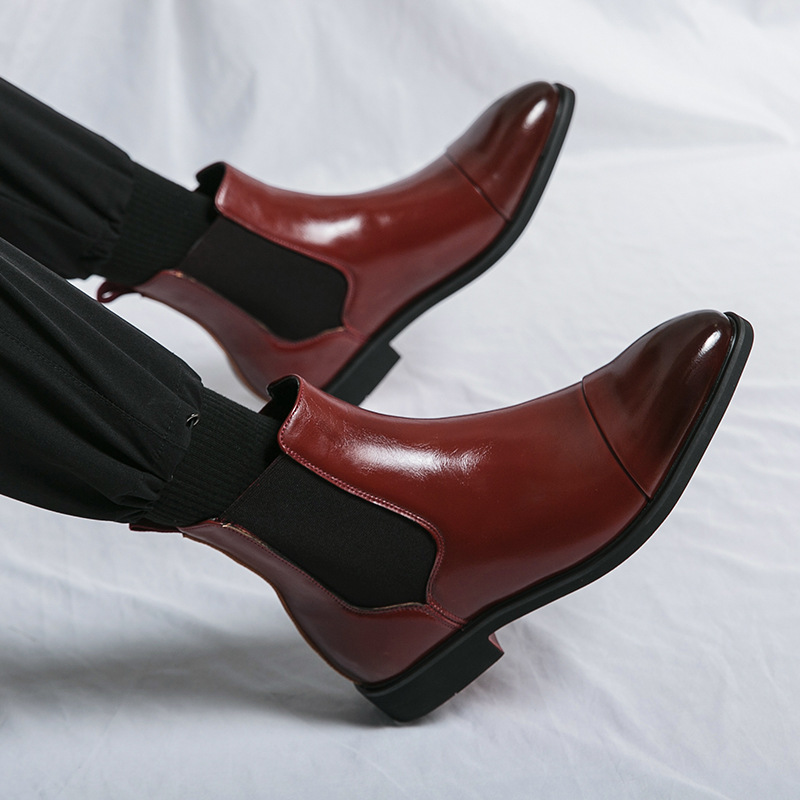 Detail view of the distinctive red sole on men's sharp Chelsea boots, emphasizing quality and style.