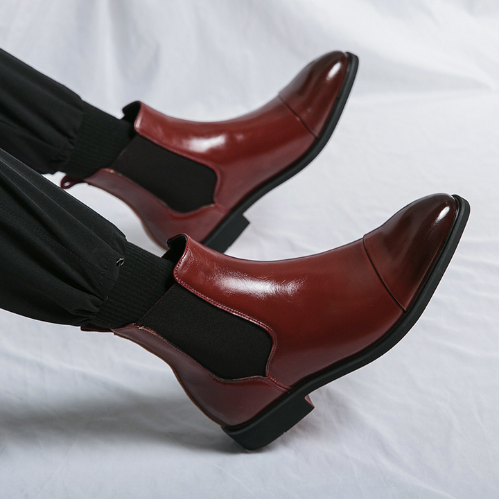 Detail view of the distinctive red sole on men's sharp Chelsea boots, emphasizing quality and style.