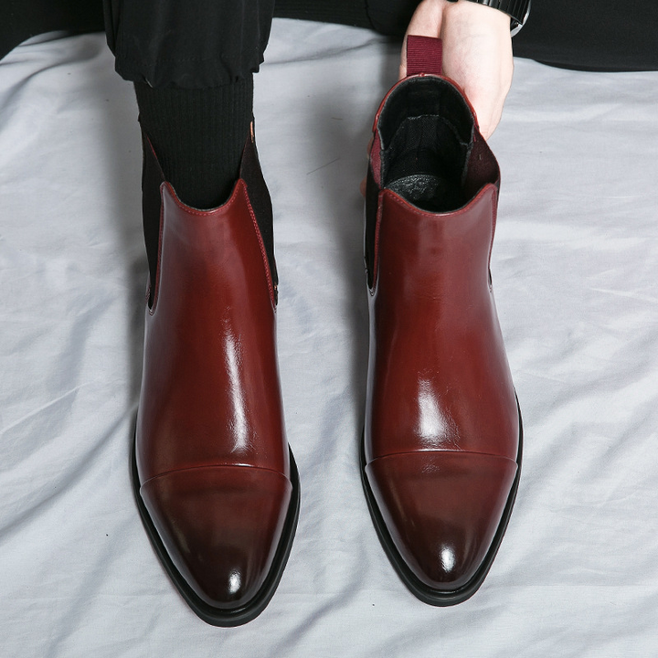 Men's comfortable slip-on Chelsea boots in polished black leather, finished with a unique red sole.