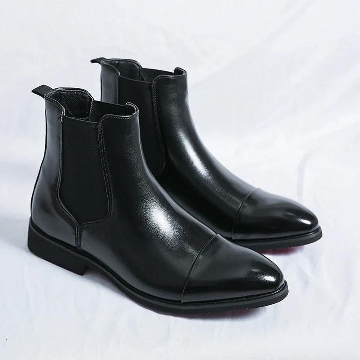 Classic men's Chelsea ankle boots, slip-on comfort, featuring a unique red outsole. Versatile footwear.