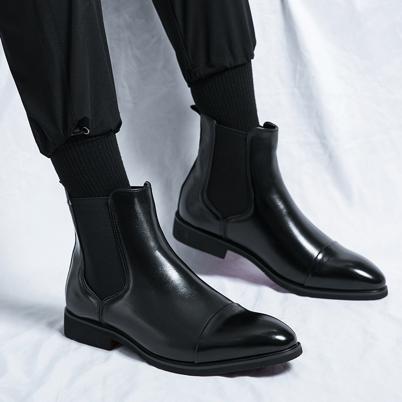 Close-up of a men's brown leather Chelsea boot, highlighting the sleek silhouette and vibrant red sole.