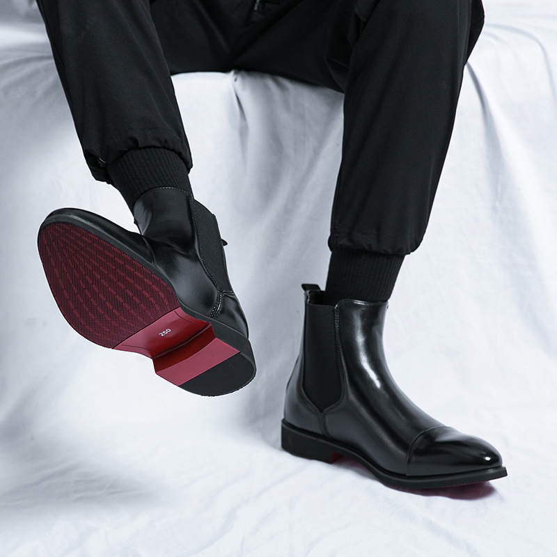 Elegant men's dress shoes: black Chelsea boots with a striking red sole, ideal for modern gentlemen.