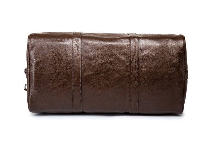 Close-up of the textured leather on a men's black travel duffel bag, highlighting material quality