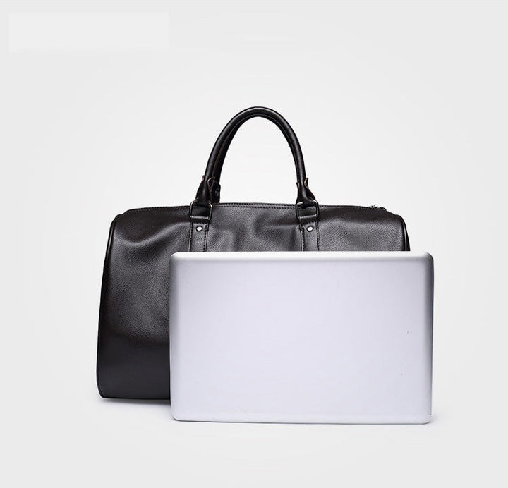 Close-up of a men's large leather travel duffel bag in black, showcasing fine grain and craftsmanship
