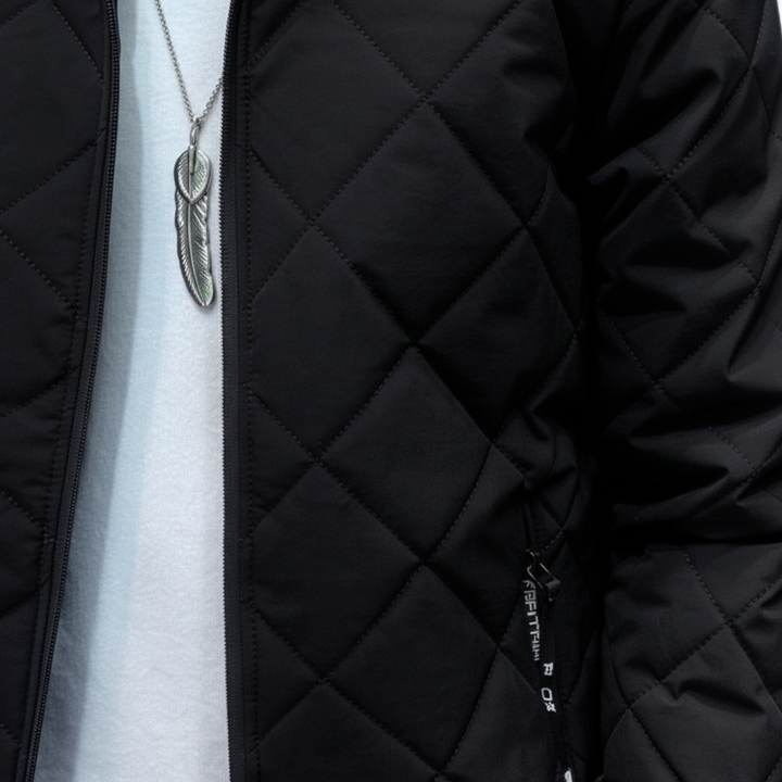 Close-up of a men's quilted winter coat in black, showing fabric detail and hood.