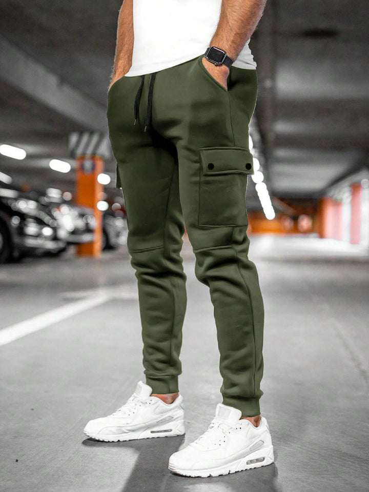 Man wearing black slim-fit streetwear jogger pants, showcasing modern casual fashion.