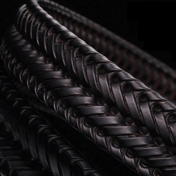 Shiny brass buckle detail on a men's braided full-grain leather belt, a durable fashion accessory.
