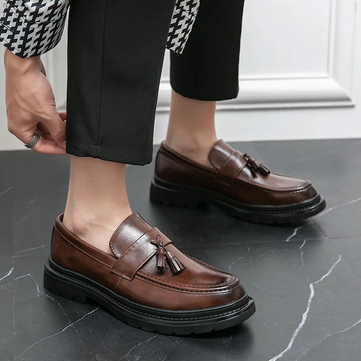 Close-up of mens brown tassel loafers, highlighting premium leather and elegant design.