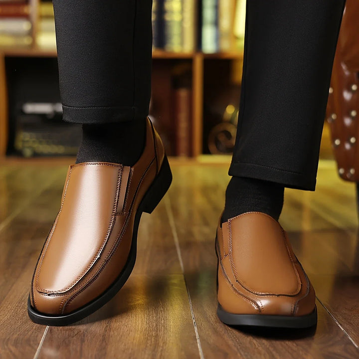 Man wearing comfortable brown Oxford loafers. Stylish slip-on dress shoes, perfect for casual or formal occasions.