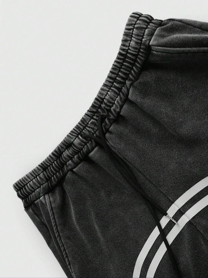 Black men's Catania track pants, tapered fit, with functional zip hems for street fashion.