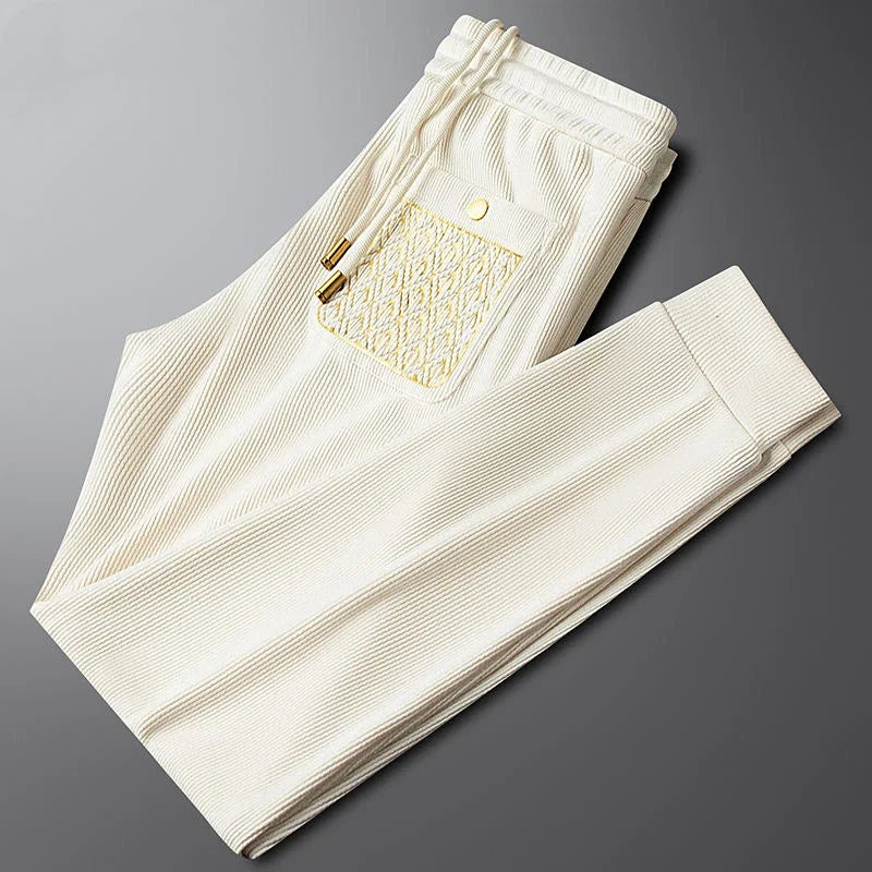 Luxe men's Cavo comfort trousers, stylish bottoms for travel with signature gold trim.