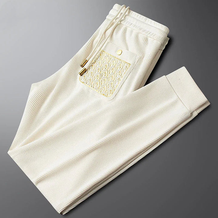Luxe men's Cavo comfort trousers, stylish bottoms for travel with signature gold trim.