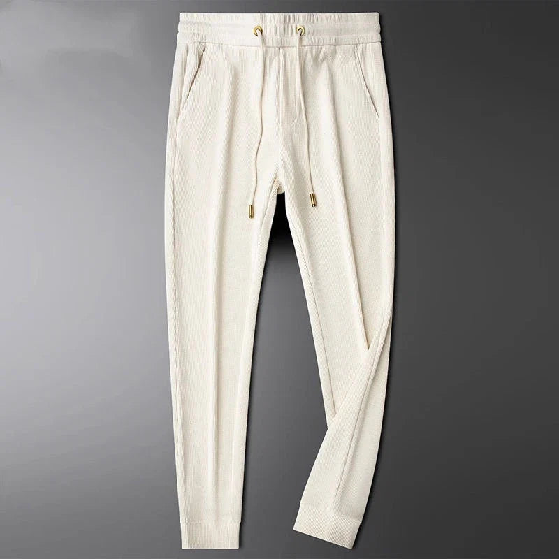 Comfort-focused men's Cavo trousers, versatile bottoms featuring elegant gold accents.
