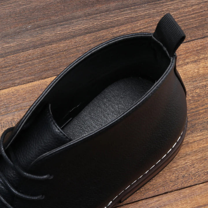 Close-up of men's black chukka boots, highlighting the comfortable, non-slip grip sole for secure traction.