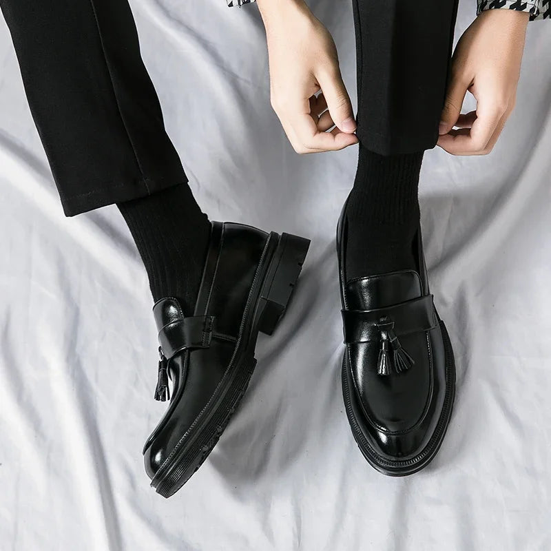 Side profile of men's classic brown leather tassel loafers. Formal slip-on dress shoes for business attire.