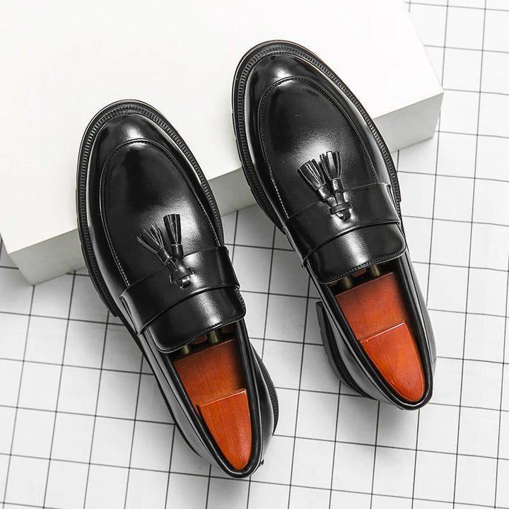 Top view of men's classic black leather tassel loafers. Stylish & comfortable slip-on footwear.