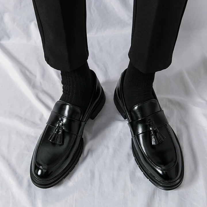 Comfortable men's black leather tassel loafers. Elegant slip-on casual & business footwear for daily wear.