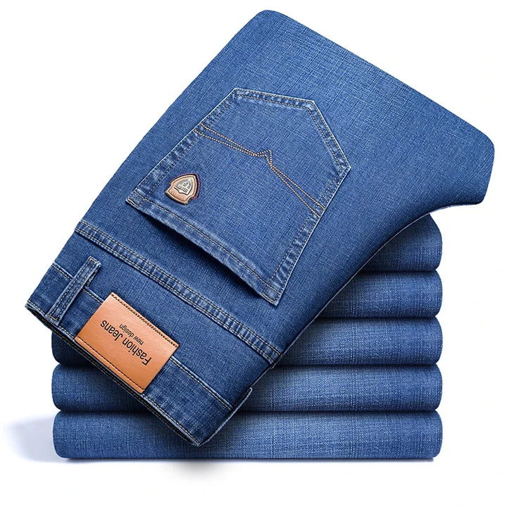 Man wearing classic blue stretch denim jeans, standing confidently, showcasing everyday casual style.