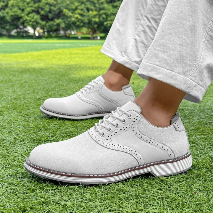 Detail shot of men's classic brogue golf shoes, showcasing rich leather texture & spiked sole.