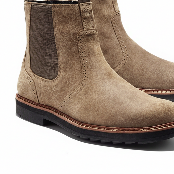 Close-up of a men's classic leather Chelsea boot in dark brown, showing elastic side panels