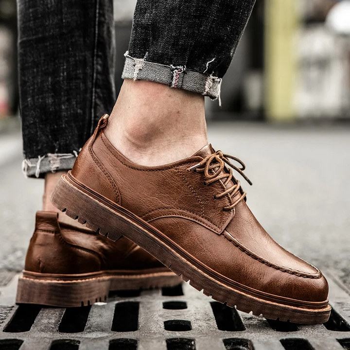 Close-up of men's classic black lace-up Derby shoes, showcasing quality leather and stitching. Formal men's footwear.