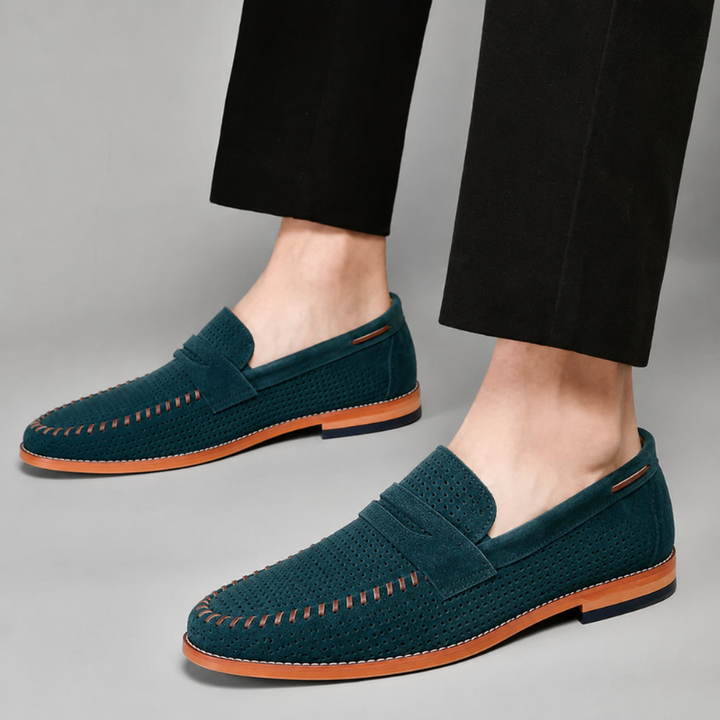 Close-up of a men's classic brown penny loafer shoe, showing detailed stitching and polished finish.