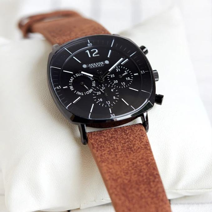Men's classic dress watch on wrist, paired with a suit for a sophisticated and timeless look.