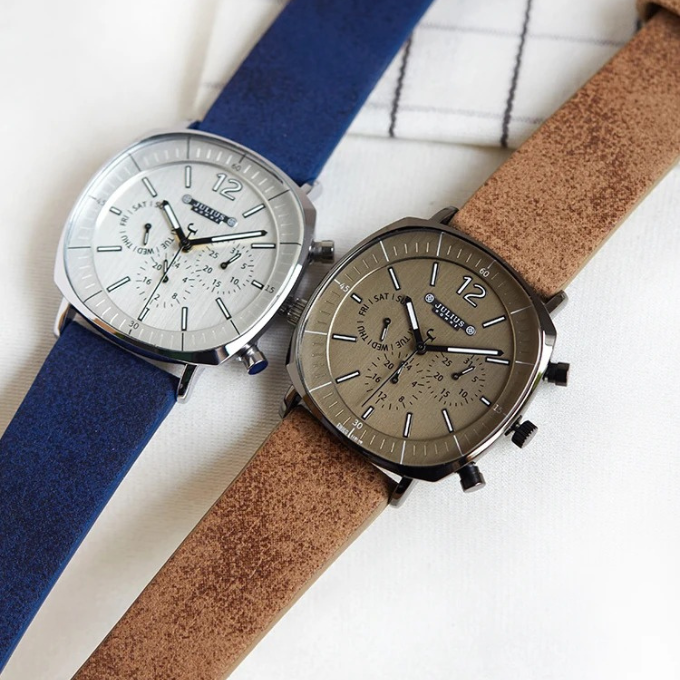 Side profile of a men's classic leather strap watch, showing detailed crown and polished silver case.