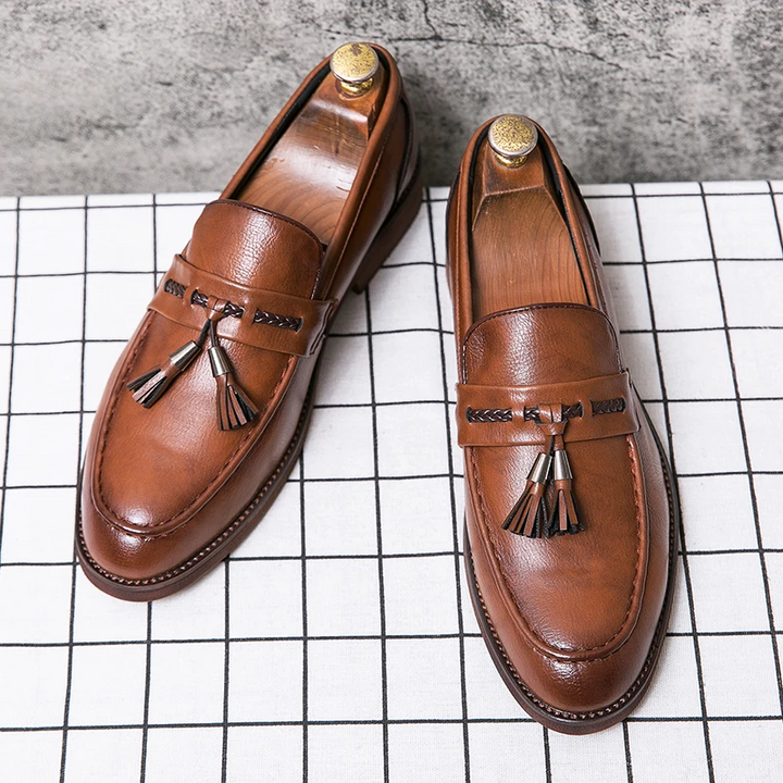 Sophisticated men's dress shoes: classic black tassel loafers with a sleek, comfortable design.