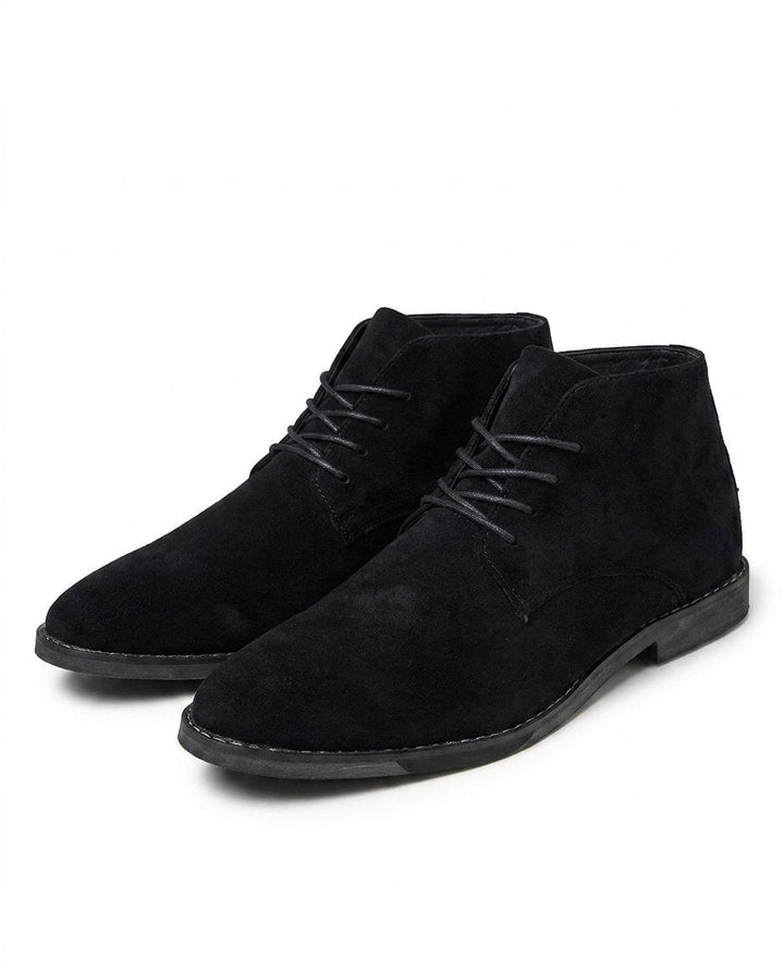 Close-up of men's classic brown suede ankle boots, showing detailed lace-up closure & sturdy sole.
