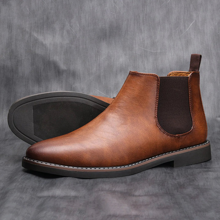 Stylish black leather men's Chelsea boots, versatile for dress or casual, easy slip-on comfort.